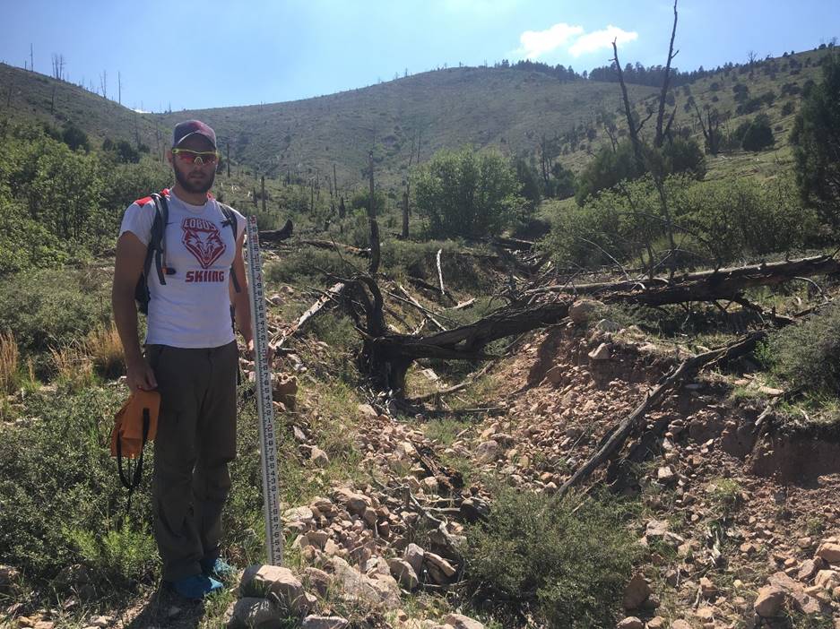 A person standing in front of a mountain

Description automatically generated