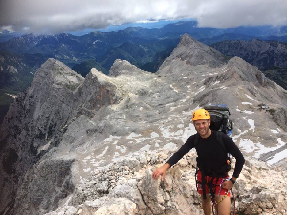 A person standing in front of a mountain

Description automatically generated