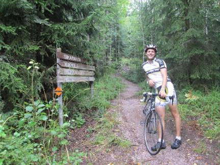 A person riding a bicycle on a trail in a forest

Description automatically generated